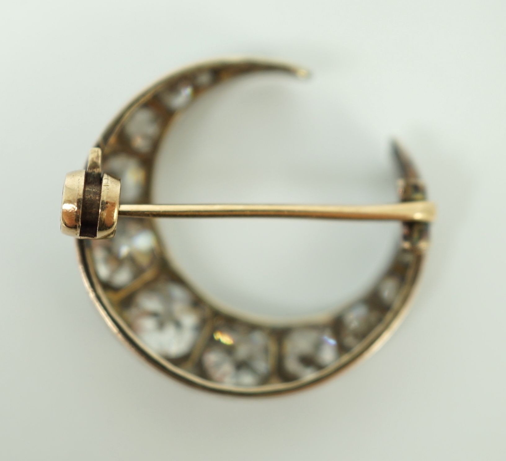 A Victorian gold, silver and graduated thirteen stone diamond set crescent brooch